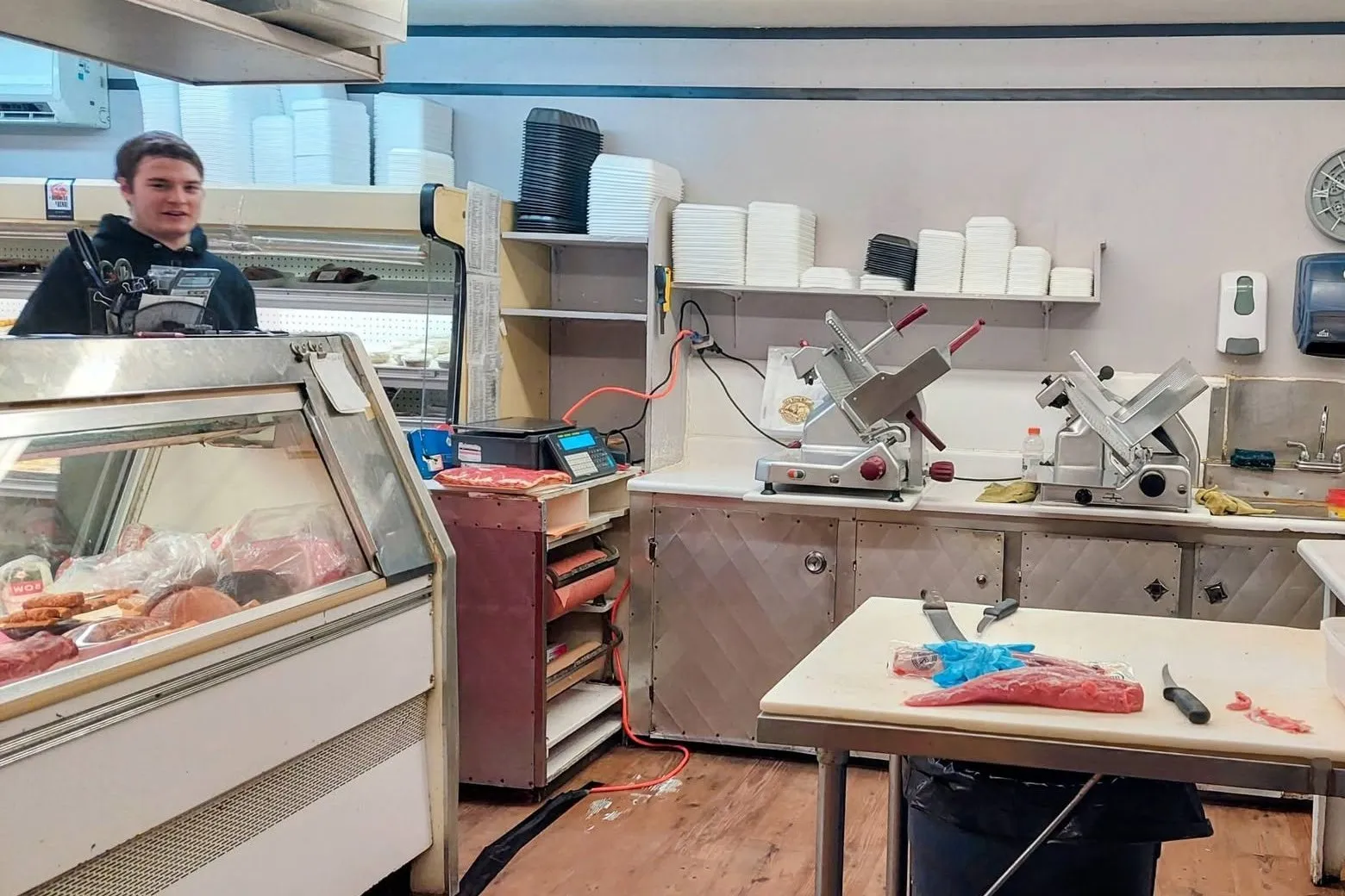 Un boucher de la Boucherie Thibault au travail derrière la vitrine réfrigérée.